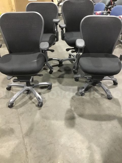 4 black office chairs; with black padded armrests "DH"