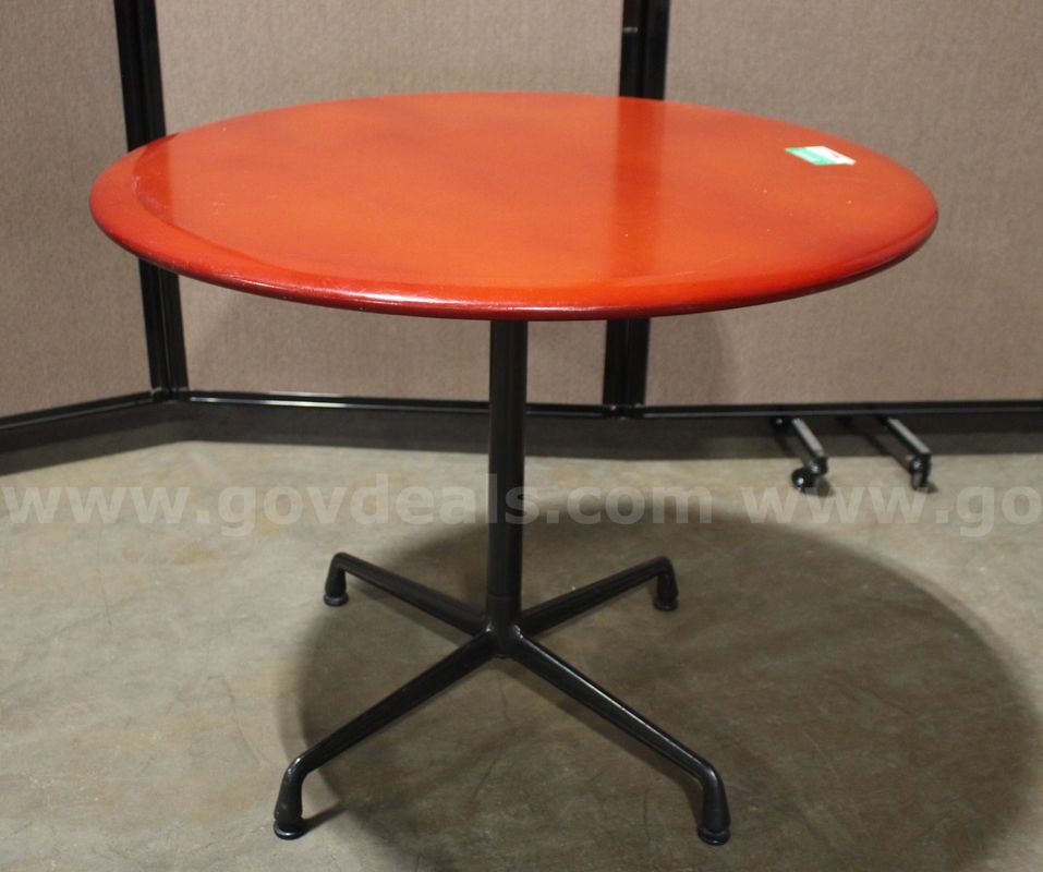 (1) Round Herman Miller pedestal table with a red laminate top and black four-star steel base.