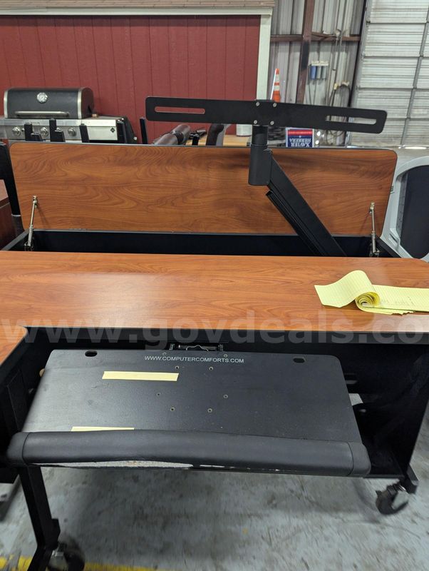 Used workstation desk with pop-up monitor arm, wood‑grain top and rolling base