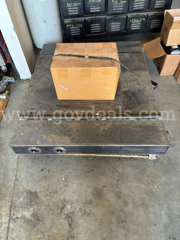 Unused behind truck cab hydraulic oil tank and various fittings.