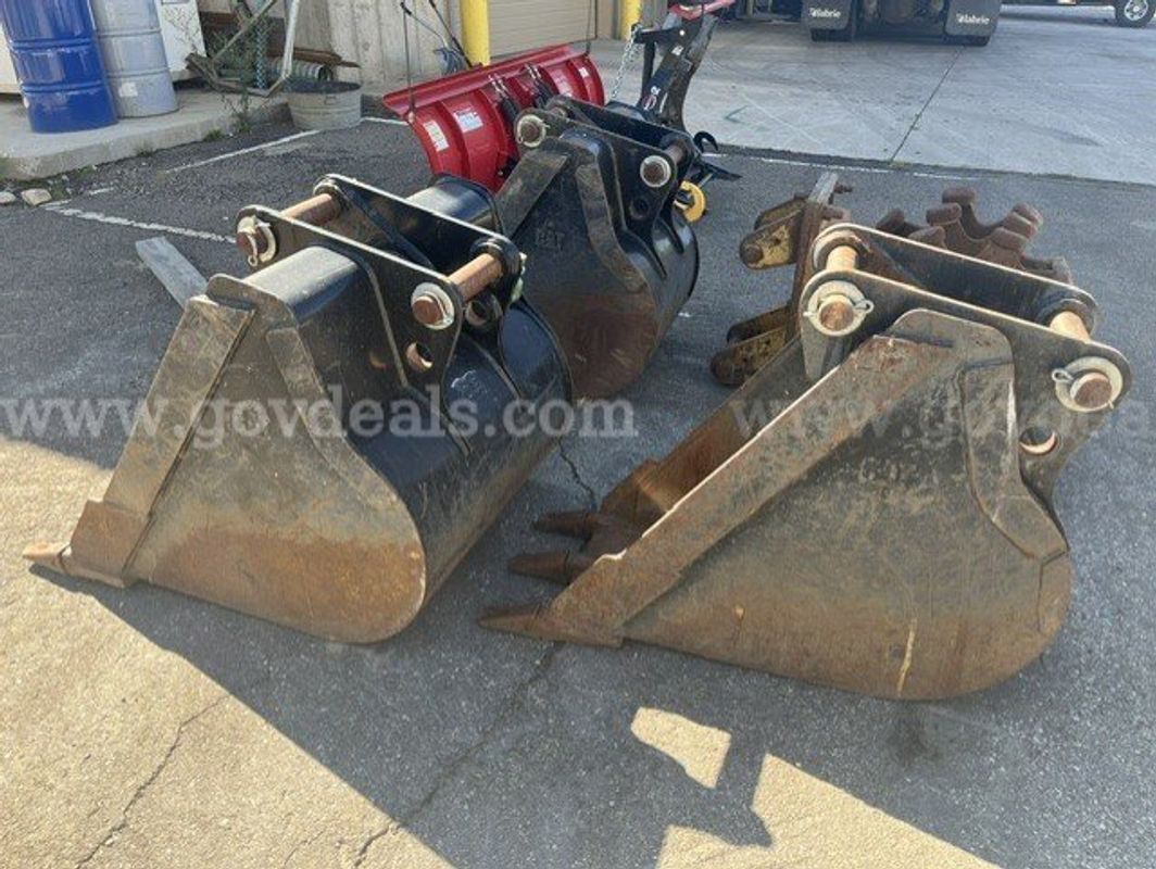 Lot of CAT buckets and a sheep foot compactor
