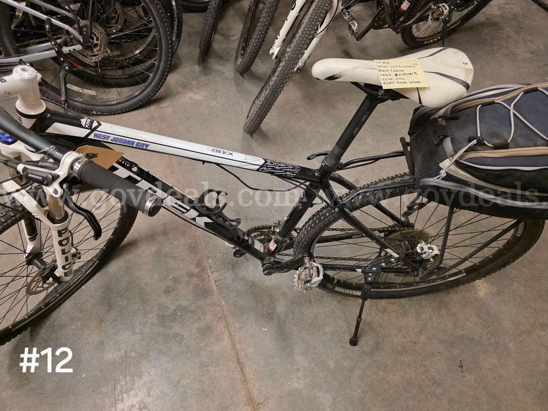 Used black and white Trek Xcaliber bike. Bike tires are flat. Front brake issues.