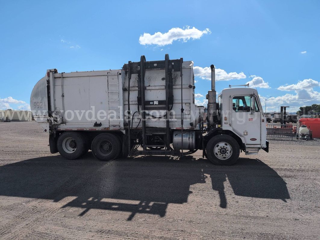 2002 Peterbilt 320 with Impac 32 yd commercial side load refuse body