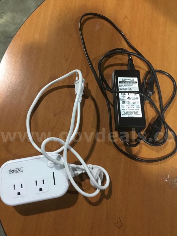 White Foval travel adapter, & a black acid battery “DH”