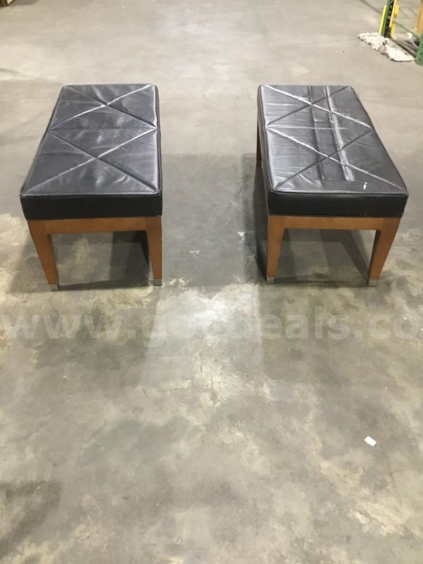 Two 48 1/2 x 28 1/2 black leather bench seats; with four brown leg wood stands "DH"