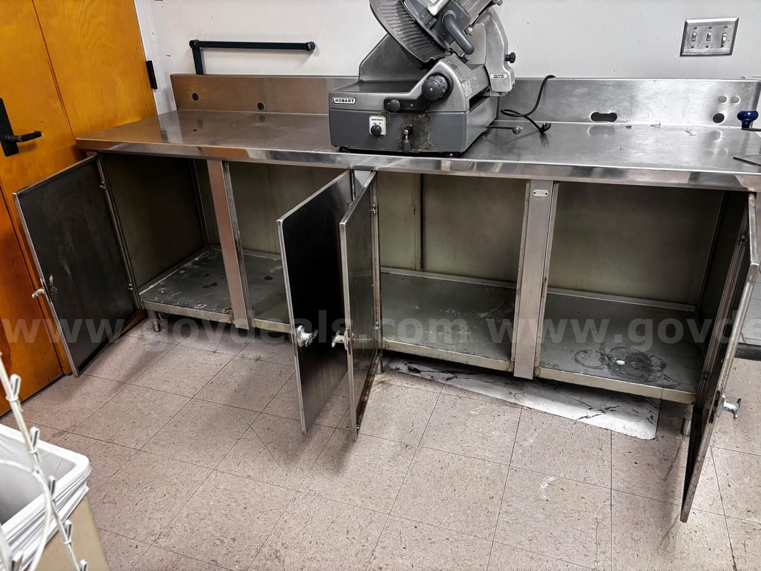 Used stainless steel commercial prep counter with storage. Slicer shown is not included. Counter only.