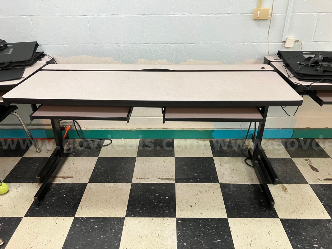 10 smaller tables with keyboard drawers and 2 larger trapeziod tables