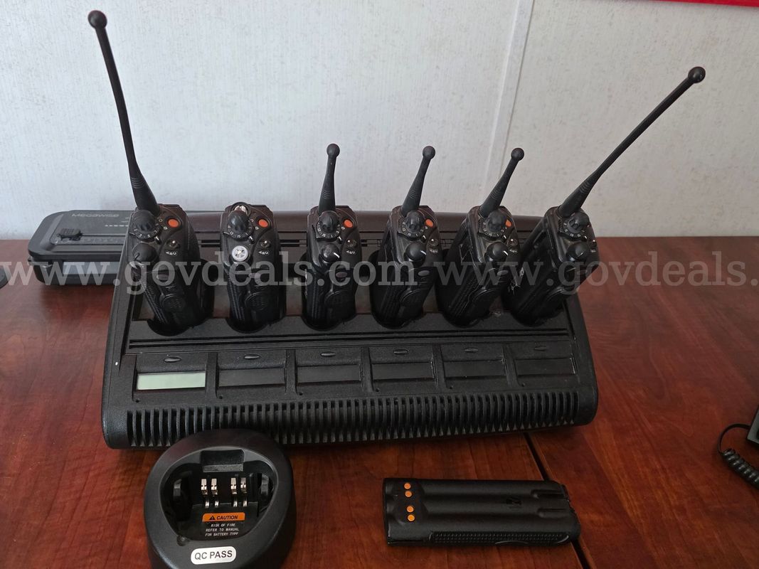 Surplus lot of six (6) Motorola XTS 5000 portable radios, one (1) 6-bay multi-unit gang charger, one (1) single-bay char