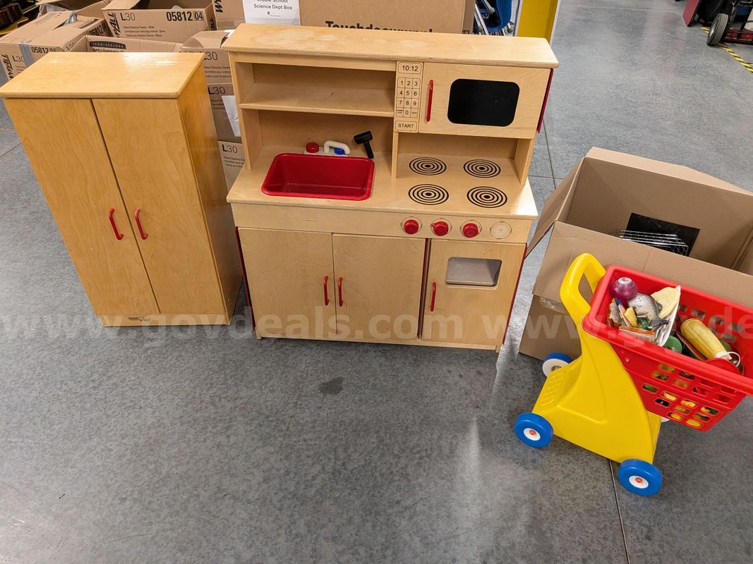 Children's play kitchen with shopping cart and toy groceries