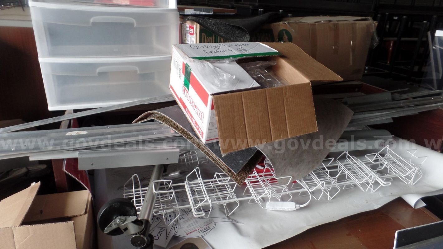 Desk, 4 tables, ceiling tile, metal pieces, carpet, 3 tier plastic cabinet, 2 trash cans.
