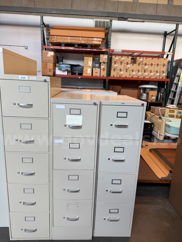 Lot includes three (3) four-drawer vertical metal filing cabinets in assorted gray finishes. These filing cabinets were