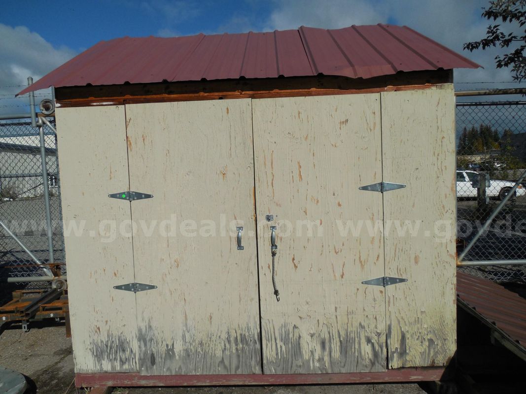 Wooden storage shed with additional roof segment